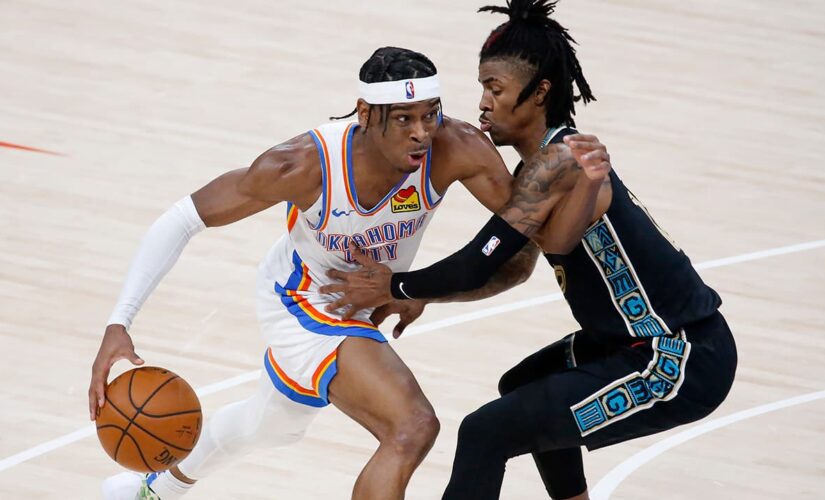 Thunder’s Shai Gilgeous-Alexander gets support from teammate Lu Dort while getting COVID-19 vaccine