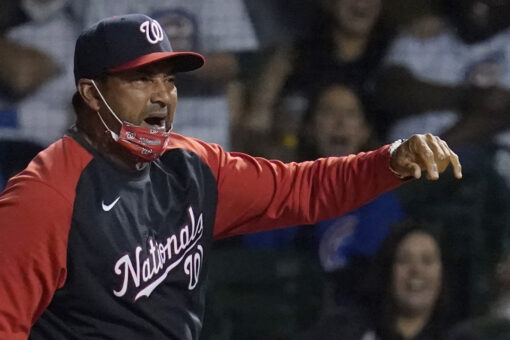 Nationals’ Dave Martinez throws first base after getting ejected from game