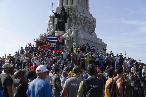 Cuban anti-government protesters wave American flags during march