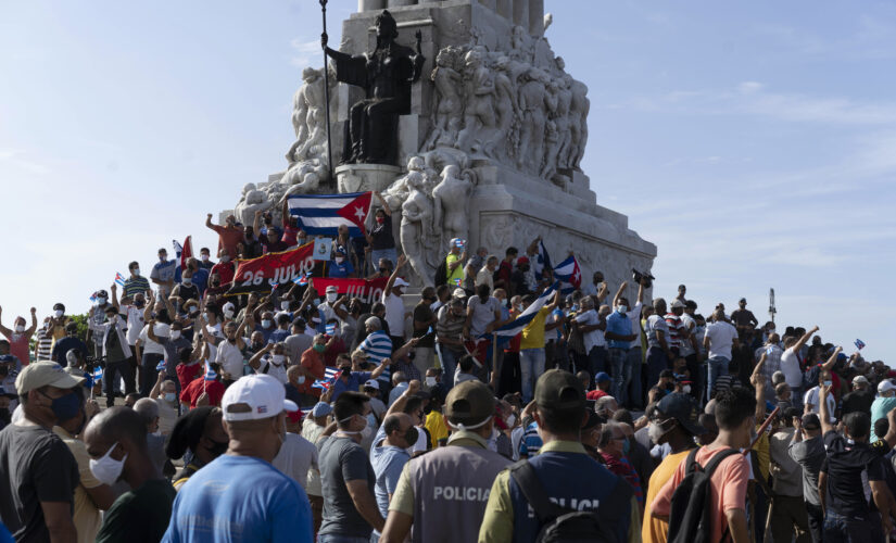 Cuban anti-government protesters wave American flags during march