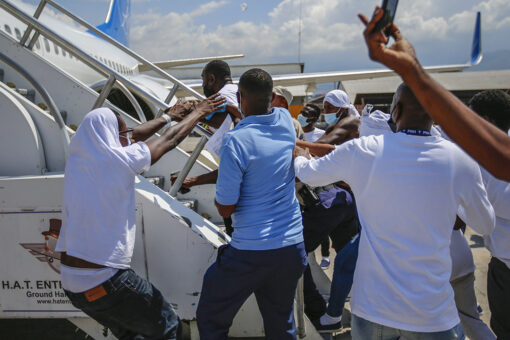 Expelled Haitian migrants try to get back on plane returning to US