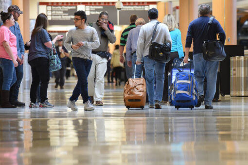 Mystery woman struts through airport wearing only a bikini and mask