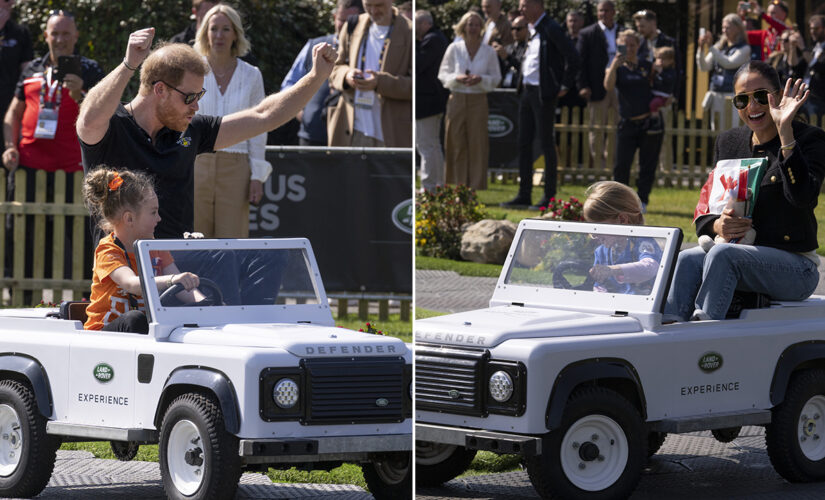 Prince Harry and Meghan Markle all smiles while riding miniature Land Rovers at Invictus Games event