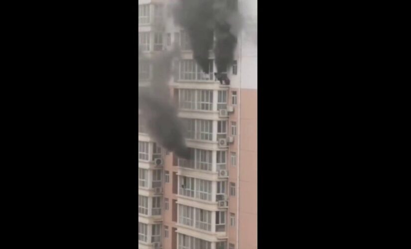 Video captures China residents clinging to ledge as fire rages in high-rise apartment building